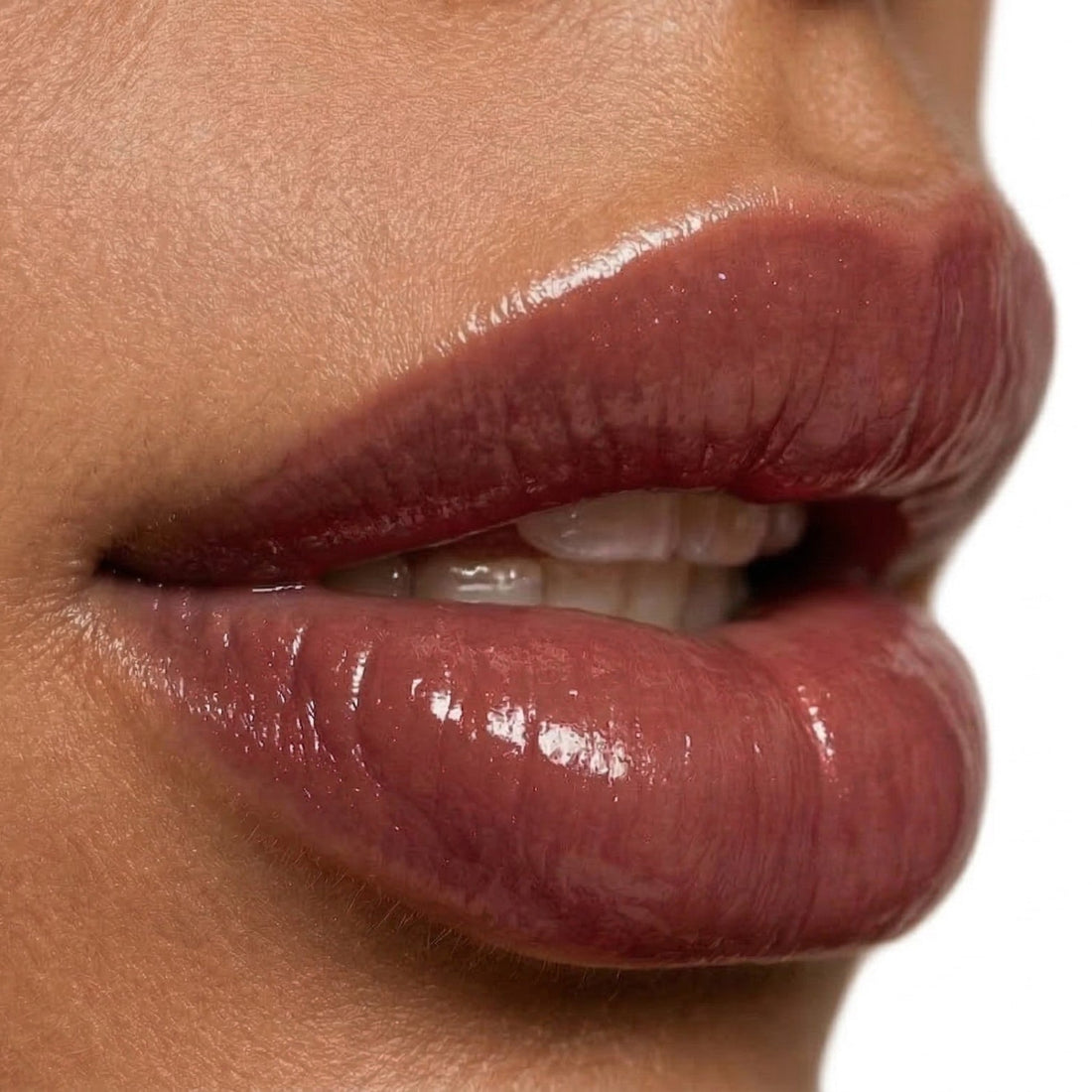 Close-up of glossy lips with a neutral background