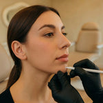 Profile view of NP injector marking chin projection zone during chin filler consultation at HoneMD Torrance